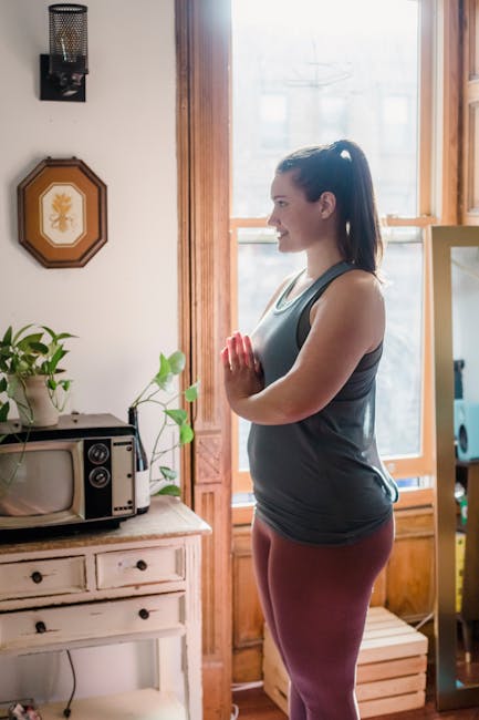 Woman starting her morning with a calm yoga pose in a dark, atmospheric room